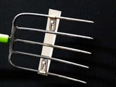 Detailed image of the fork-blade attachment accessory's sharp tines and mounting.