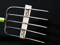 Detailed image of the fork-blade attachment accessory's sharp tines and mounting.