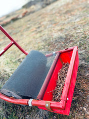 The sticker roller product is being used to efficiently clean a grassy area of burrs and stickers.